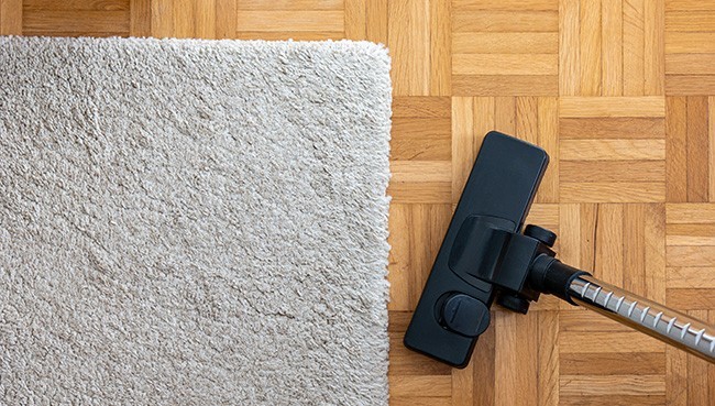 Vacuum cleaner extension on a laminated wooden floor | Sterling Carpet & Flooring