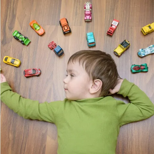 Boy laying on floor with toys | Sterling Carpet & Flooring